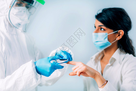检查血氧水平和的医务人员身戴保护外科手术面罩的病人图片