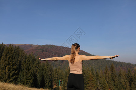 运动女青年在山上做自然伸展练习运动女青年在腿上做瑜伽美丽的森林景观青年女在山上做自然伸展练习图片