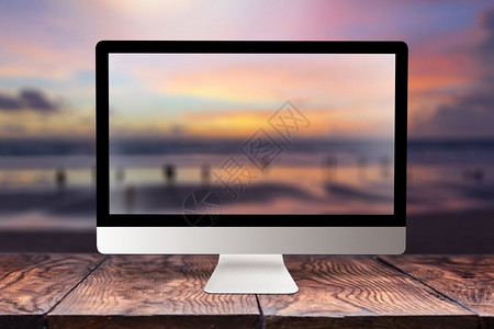 用日落海景模糊的图片在木制桌子上显示背景与bokeh相同复制空间远程在海面岸自然办公室外概念上工作计算机屏幕背景模糊海面图片