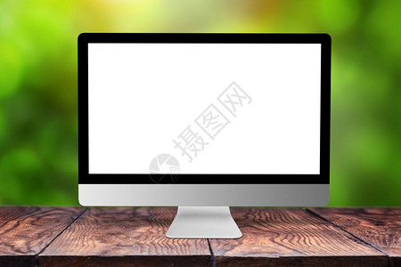 白在木制桌子上模拟计算机监视器以模糊的绿色自然背景和bokeh复制空间在办公室之外工作在木制桌子上模拟计算机屏幕以模糊的背景图片