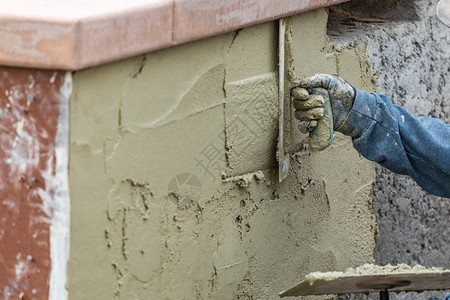 瓷砖工人在池塘建筑地用水泥加土筋图片