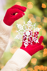 妇女穿着季节红手套带着白雪花圣诞节装饰品图片