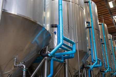 仓库中的大型啤酒酿发酵罐背景图片