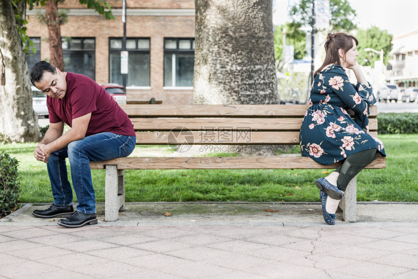 坐在公园长椅上相对不开心的一情侣图片