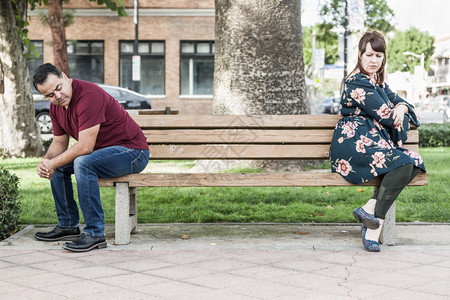 坐在公园长椅上相对不开心的一情侣图片