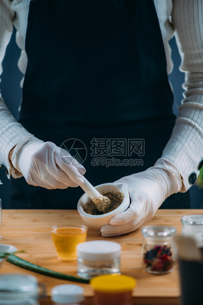 使用迫击和虫害研磨草药花粉自制化妆奶油图片