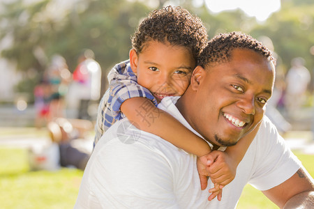 快乐的非裔美国父亲和混血儿在公园里玩图片