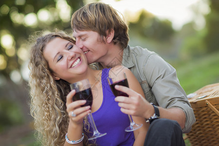 一对有魅力的情侣一起在公园喝杯酒图片