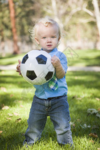小可爱男孩在公园里玩足球图片