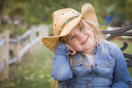 带着牛仔帽的可爱笑年轻女孩假扮在外面画肖像图片