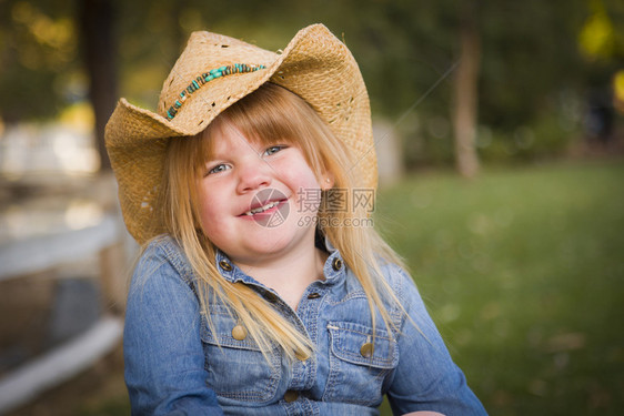 带着牛仔帽的可爱笑年轻女孩假扮在外面画肖像图片