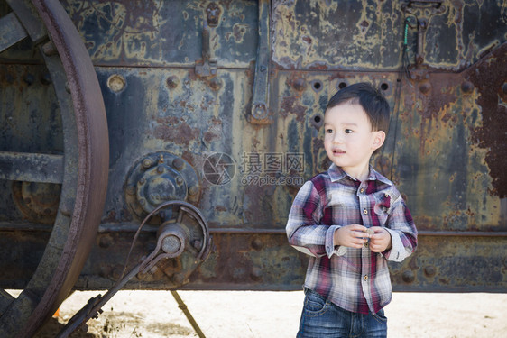 可爱的混杂种族男孩在外面的古董机器附近玩得开心图片