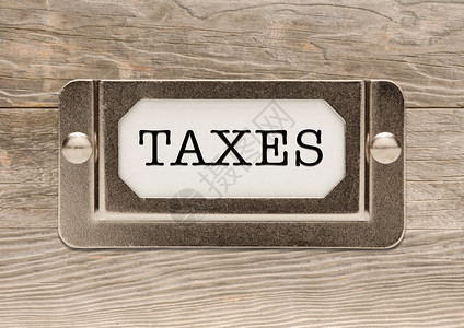 木材背景的金属文件标签框架征税图片