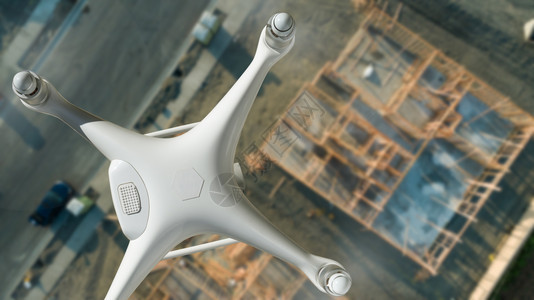 白色无人驾驶飞机在建筑工地上空飞行图片