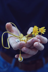 女孩手握黄色鲜花和耳机图片