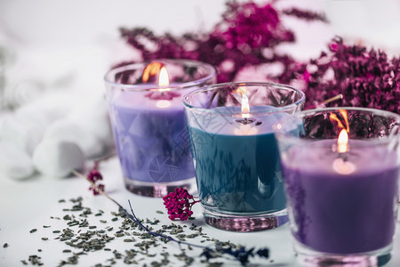 紫色和蓝香蜡烛上面有熏衣草和白桌上的干花装饰图片