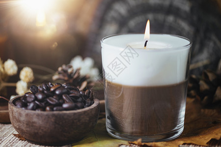双色花香咖啡和草双色芳蜡烛配有木碗中的咖啡背景