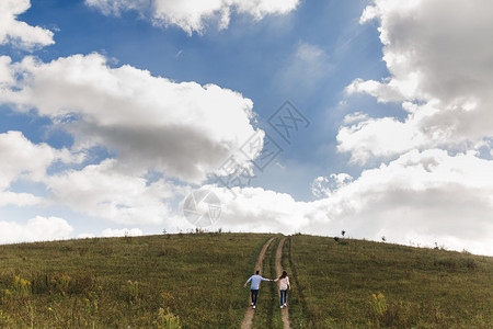 一对浪漫的夫妻牵着手一起爬山图片