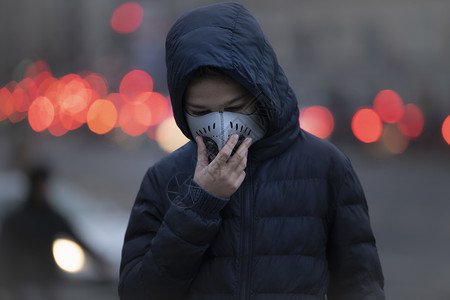 身着防污染面具受空气城市街道的年轻人图片