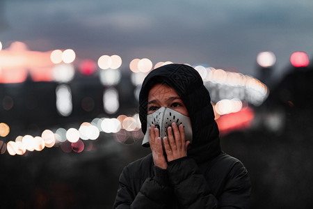 空气污染概念城市中带呼吸面具的年轻人高清图片