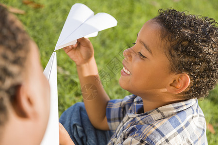 混合种族父子在公园玩纸飞机图片