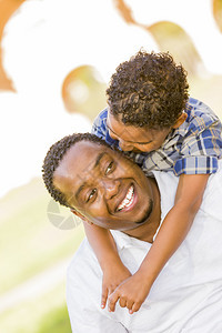 快乐的非裔美国父亲混血儿在公园里玩图片