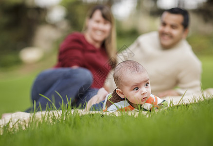 快乐的混合种族婴儿男孩和父母在公园户外玩耍图片