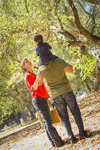 有野餐篮子的幸福混合种族家庭享受在公园散步图片
