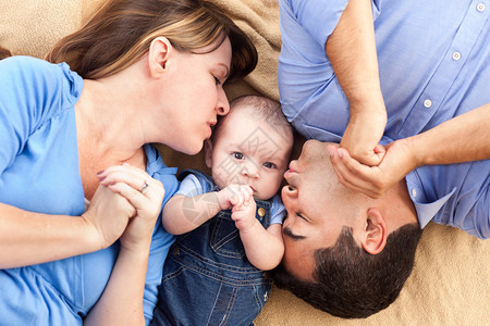 混合种族家庭有婴儿在毯子上打脸图片