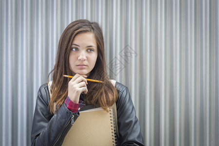 漂亮的年轻忧郁女学生书本和铅笔都靠边看图片