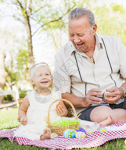 祖孙两人在野餐垫子上给蛋壳绘画背景图片