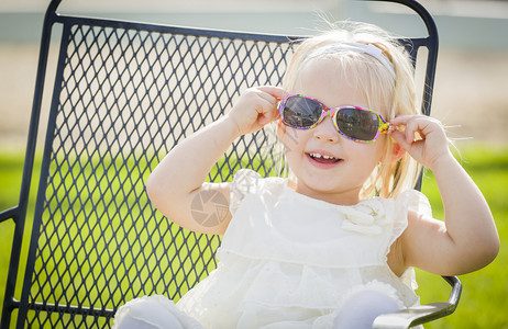 可爱的嬉皮女婴穿着太阳镜在公园外面图片