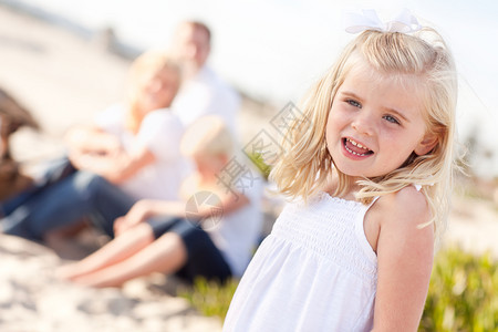 可爱的金发小姑娘和家人在海滩玩得开心图片