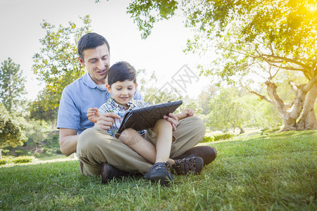 父亲和儿子在外边的电脑板上玩耍图片