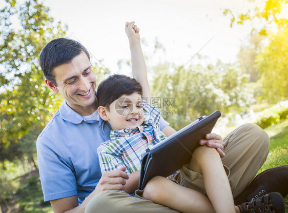 父亲和儿子在外边的电脑板上玩耍图片