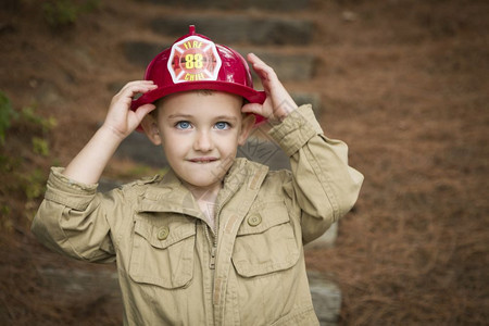 可爱的男孩消防员帽子在外面玩图片