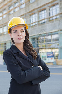 年轻有吸引力的女专业承包商在建筑工地戴硬帽的肖像图片