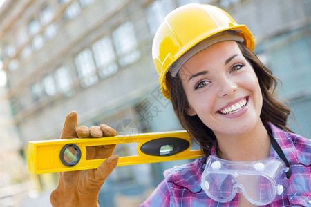 年轻有吸引力的女建筑工人肖像在建筑工地身着手套硬帽和护目镜图片