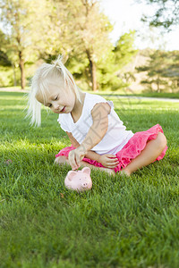 可爱的小女孩在草地上和她的小猪库玩得开心图片