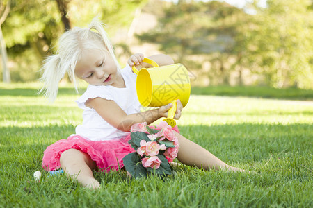可爱的小女孩玩园艺用她的工具和花盆图片