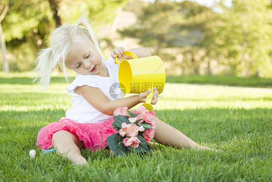 可爱的小女孩玩园艺用她的工具和花盆图片