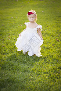 美丽的可爱小女孩穿着白色衣服在草场上图片