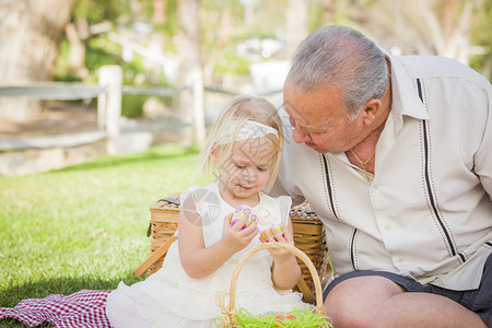 祖孙两人在野餐垫子上玩彩色蛋壳图片