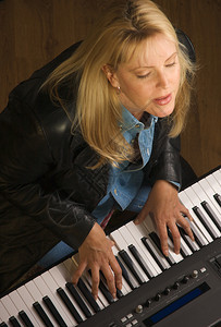 女音乐家在弹数码钢琴时唱歌图片