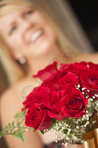 令人惊讶的金发美女接受了红玫瑰的礼物图片