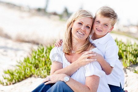 可爱的儿子在海滩边开心的拥抱着妈妈图片