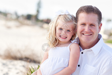 可爱的女儿抱和她英俊的爸在海滩图片