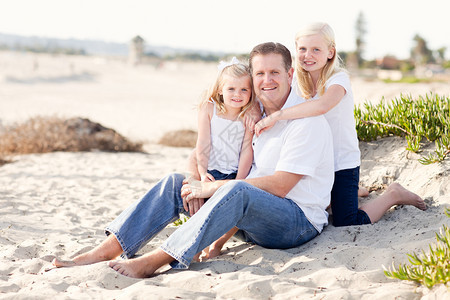 父亲带两个可爱的女儿在海滩上开心的玩耍图片