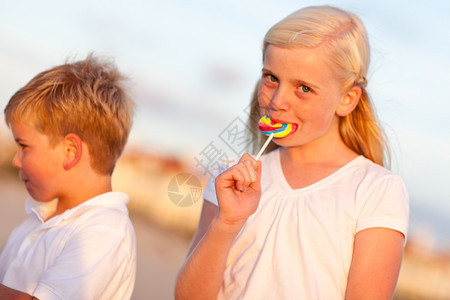 可爱的小女孩和弟享受他们的棒糖一天下午图片