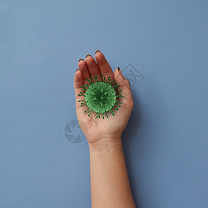 妇女手持3d型冠状细菌以钢蓝为背景在冠状流行期间定洗手作为一种预防方法的概念covid193使女用冠状细菌为模型图片